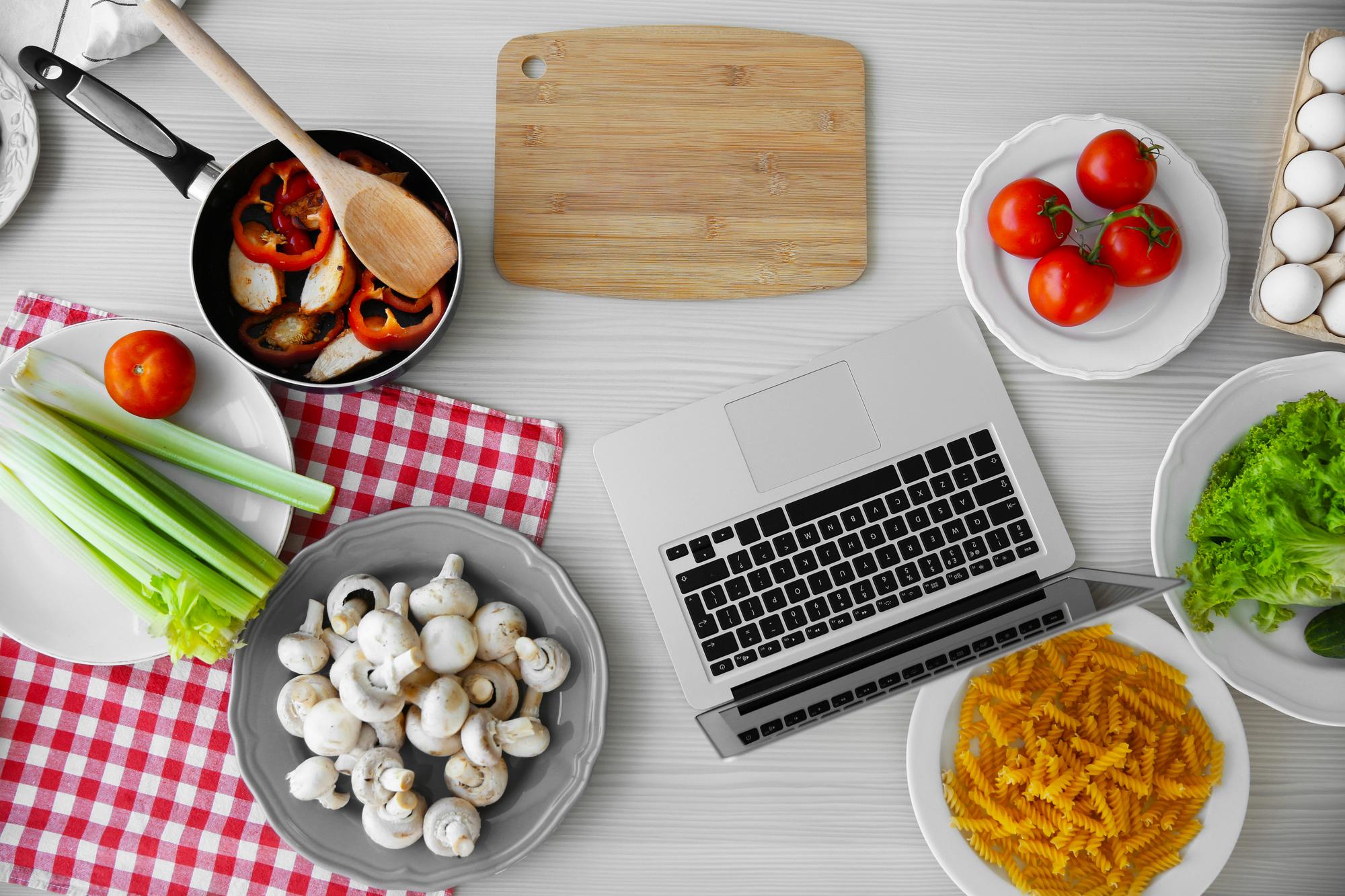 Tavolo con strumenti da cucina e laptop